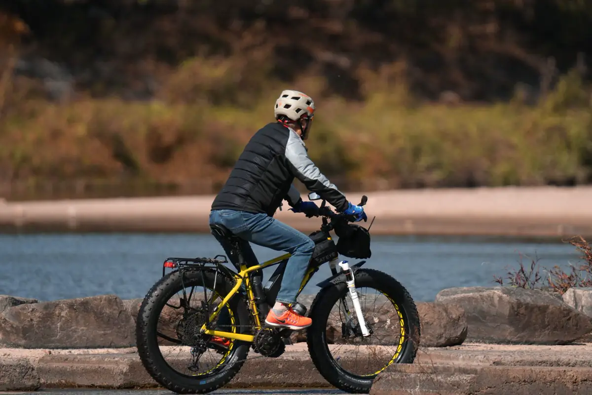 A rider travels a riverside path on a fat-tire bicycle.